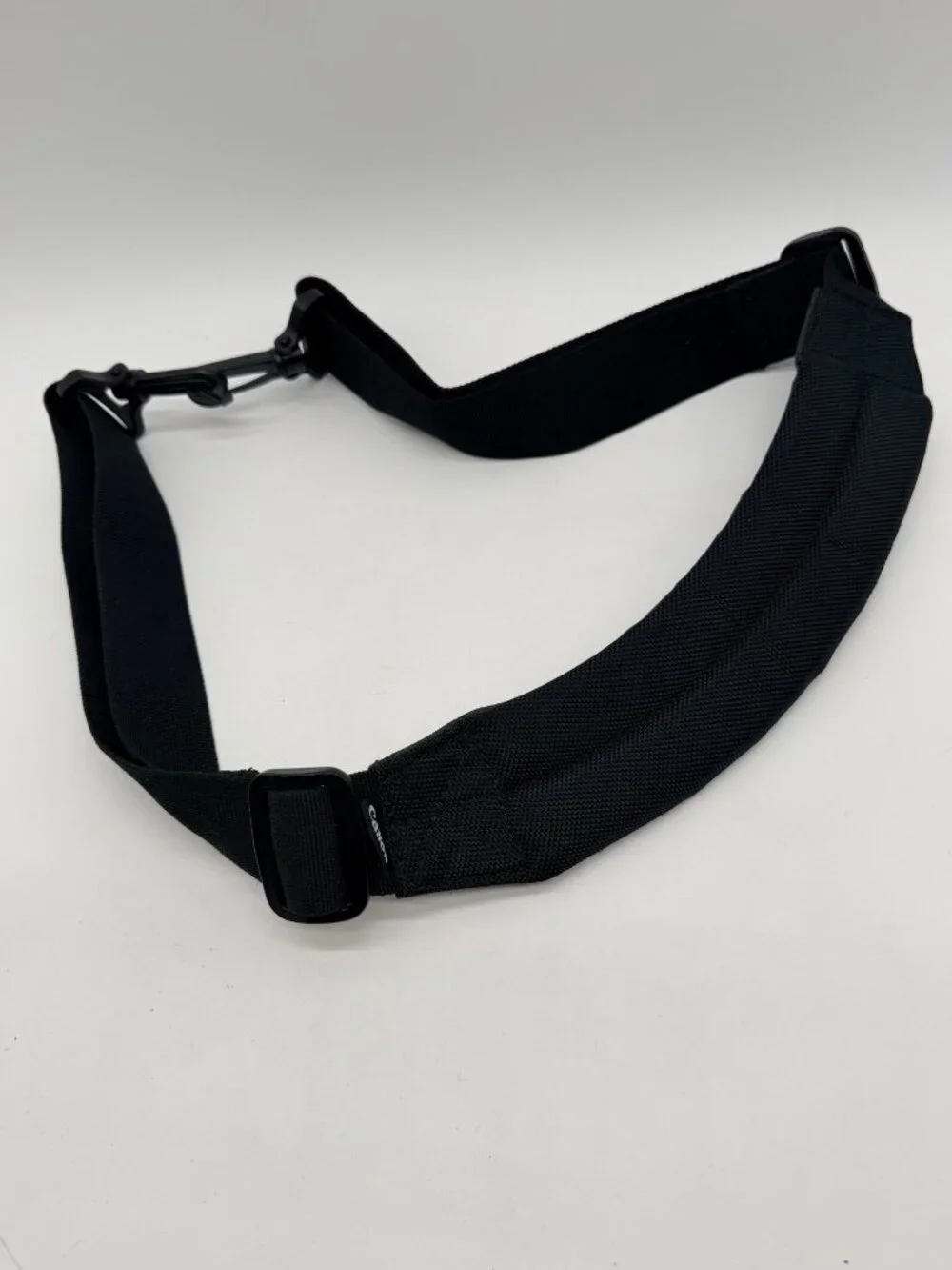 black Canon padded camera shoulder strap featuring an adjustable nylon web belt